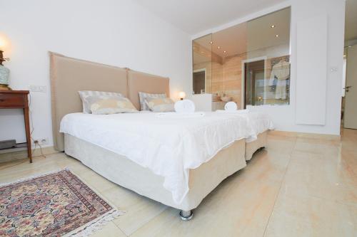 Cette chambre comprend un grand lit blanc et un miroir. dans l'établissement Appartement privé vue mer Cannes centre Gray d'Albion, à Cannes