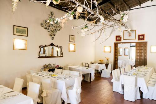 una sala da pranzo con tavoli bianchi e sedie bianche di Agriturismo Casalicchio a Cammarata