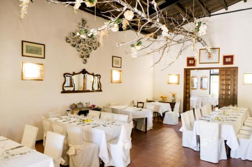 un comedor con mesas blancas y sillas blancas en Agriturismo Casalicchio, en Cammarata