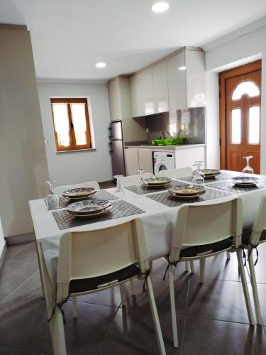 a kitchen with a white table and chairs and a kitchen with at Casa da quintinha - Turismo rural in Arcos de Valdevez