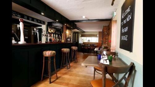 a bar with chairs and tables in a restaurant at Halfway Bridge in Midhurst