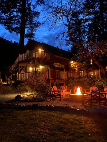 a log cabin with a fire in front of it at night at Weasku Inn in Grants Pass