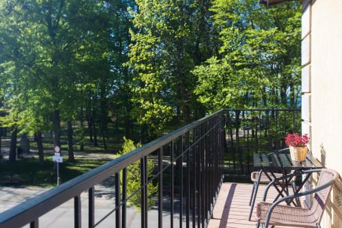 a balcony with a table and a bench and trees at Fregata in Ustka