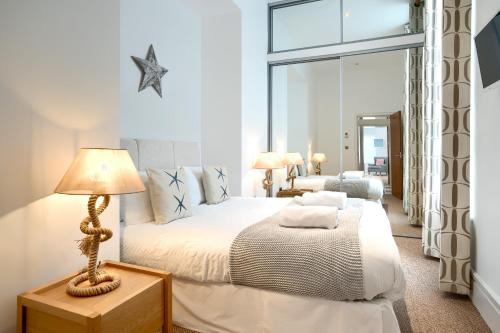 ein Schlafzimmer mit einem Bett, einer Lampe und einem Fenster in der Unterkunft Luxury Seaside Apartment in Eastbourne