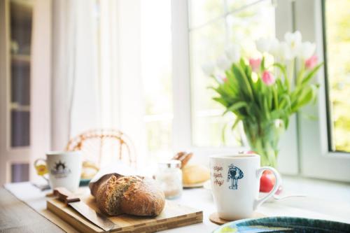 a table with coffee cups and a loaf of bread at Fregata in Ustka