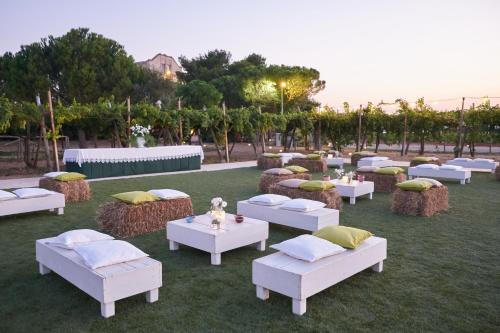 a group of white couches and tables on the grass at Masseria Agrituristica Lama San Giorgio in Rutigliano