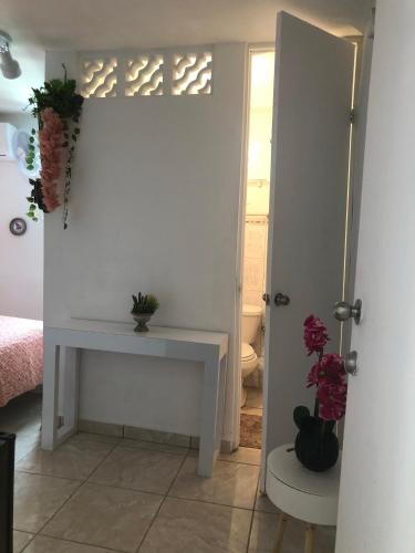 a white room with a table and a door with flowers at Gavidias Guest House in San Lorenzo
