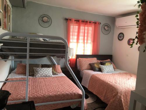 1 dormitorio con 2 literas y ventana en Gavidias Guest House, en San Lorenzo