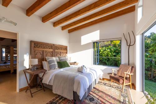 a bedroom with a large bed and a window at Karu ō te Kiwi - Your Enchanting Hideaway in Pakawau
