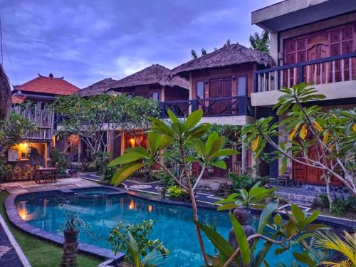 a house with a swimming pool in front of it at Satria Bungalow in Uluwatu