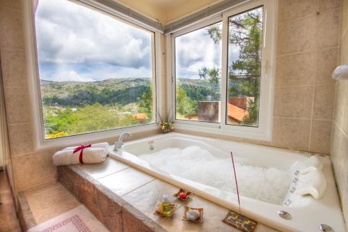 a bath tub with a large window in a bathroom at Balcones de La Cumbrecita in La Cumbrecita