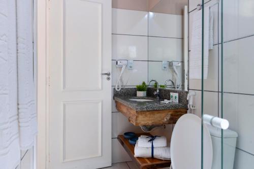 a bathroom with a marble sink and a toilet at Pousada Rio Claro in Poconé