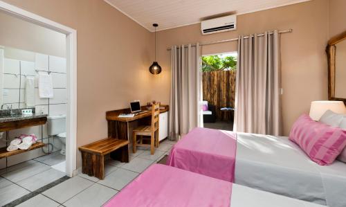 a bedroom with a bed and a desk at Pousada Rio Claro in Poconé