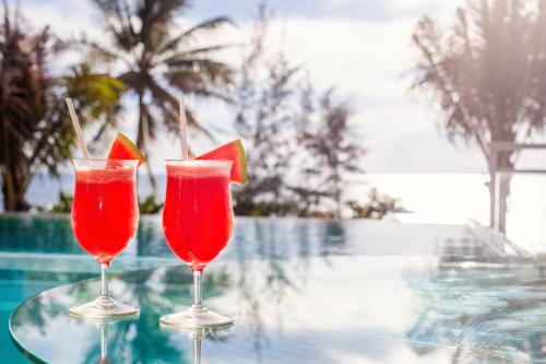 two red wine glasses sitting on top of a red table at Angsana Laguna Phuket - SHA Extra Plus in Bang Tao Beach