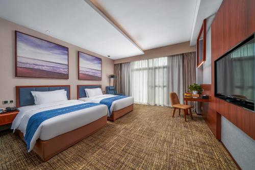 a hotel room with two beds and a flat screen tv at Ausotel Smart Baiyun International Airport T2-Canton Fair Free Shuttle 15 Oct to 4 Nov in Guangzhou