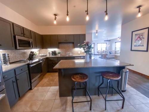 a large kitchen with a large island with two bar stools at Remodeled Ski In-Out - 305 Soaring Eagle - Luxury! in Dunmore