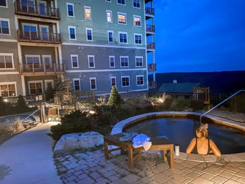 a woman laying in a swimming pool next to a building at Remodeled Ski In-Out - 305 Soaring Eagle - Luxury! in Dunmore