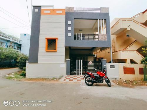 uma moto vermelha estacionada em frente a uma casa em Vizag homestay guest house em Visakhapatnam