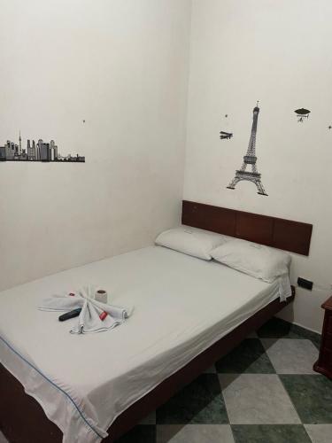a bedroom with a bed with two drawings of the eiffel tower at Hotel Policarpa in Guaduas