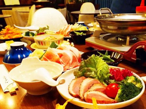 a table with plates of food on a table at Villa Alpen in Yamanouchi