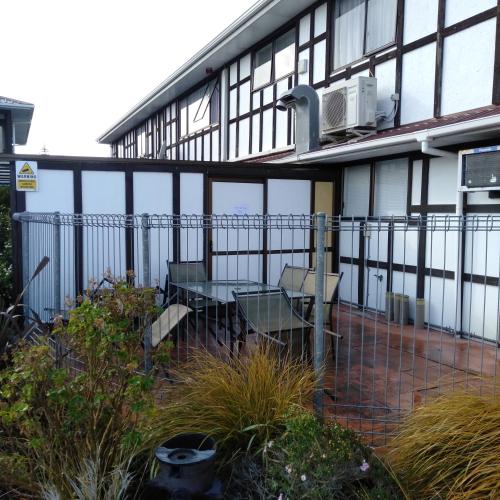 a building with a table and chairs in front of it at Albatross Motel in Napier