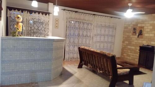 a room with a bench and a counter with curtains at Casa de praia Peruibe in Peruíbe