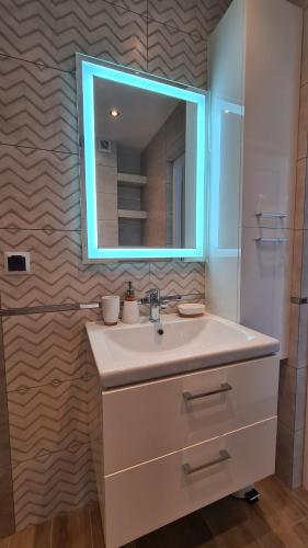 a bathroom with a sink and a mirror at Apartament DeLuxe 3 in Oświęcim