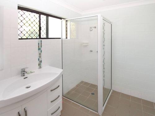 a white bathroom with a shower and a sink at Alma Bay Holiday Unit 4 in Arcadia