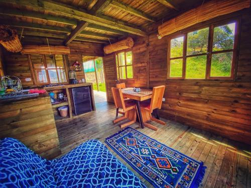 Cabaña de madera con mesa y comedor en Cabaña Agrreste en Nemocón