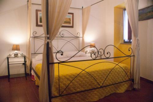 a bedroom with a yellow bed with a metal frame at La Casa Del Viandante in Radicofani