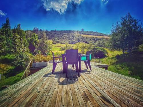 a table and chairs sitting on a deck with a view at Cabaña Agrreste in Nemocón
