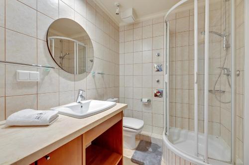 uma casa de banho com um lavatório, um chuveiro e um WC. em Lion Apartments - Santorini Studio em Sopot