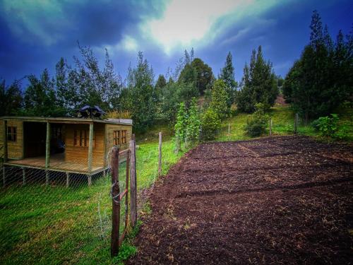 a fence next to a small building on a field at Cabaña Agrreste in Nemocón