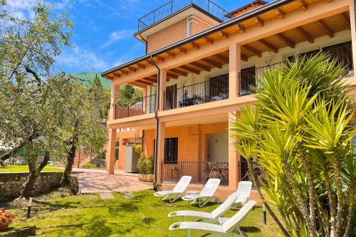 a house with white chairs in front of it at Albergo Vittoria in Toscolano Maderno