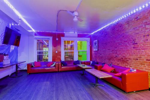 a living room with red couches and a brick wall at Lucky D's Youth and Traveler's Hostel in San Diego