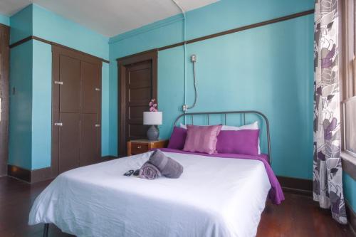 a bedroom with a bed with purple and blue walls at Lucky D's Youth and Traveler's Hostel in San Diego