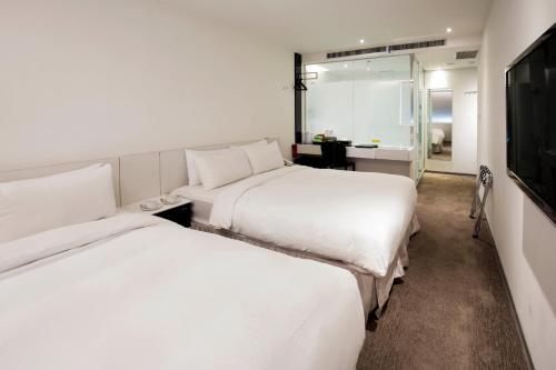 a hotel room with two beds and a mirror at CityInn Hotel Taipei Station Branch III in Taipei