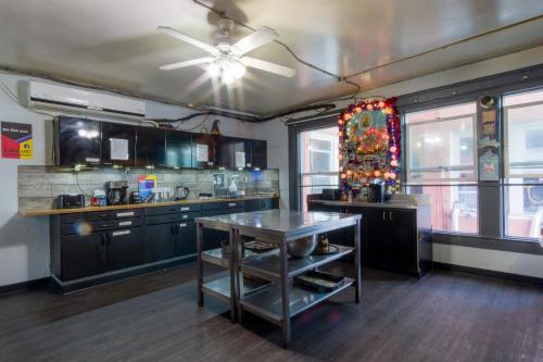 a kitchen with black cabinets and a ceiling fan at Lucky D's Youth and Traveler's Hostel in San Diego