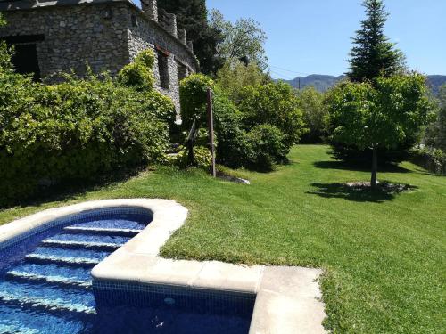 a swimming pool in a yard next to a house at Bancal de Los Pérez in Carataunas