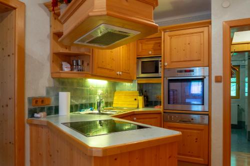 a kitchen with wooden cabinets and a stove top oven at Four Seasons Lodge in Lackenhof