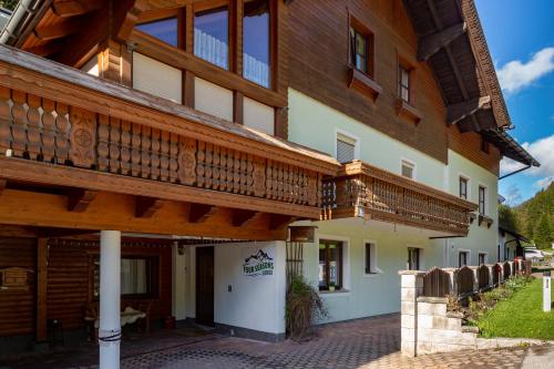 a large wooden building with a balcony on it at Four Seasons Lodge in Lackenhof