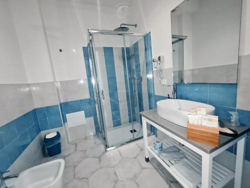 a bathroom with a sink and a shower and a toilet at Kalinifta Rooms Apartment in Torre Lapillo