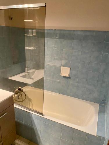 uma casa de banho com um chuveiro, uma banheira e um lavatório. em Hôtel des Alpes em Aix-les-Bains