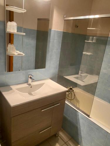 uma casa de banho com um lavatório, um chuveiro e uma banheira em Hôtel des Alpes em Aix-les-Bains