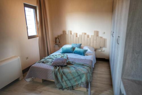 a bedroom with a bed with blue pillows on it at Villa Evinoi in Pallini