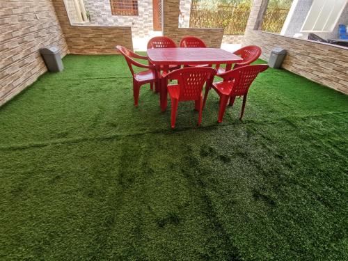 a table and chairs on a lawn with green grass at Villa Salassel Al Jabal Al Akhdar فلة سلاسل الجبل الأخضر in Al ‘Ayn