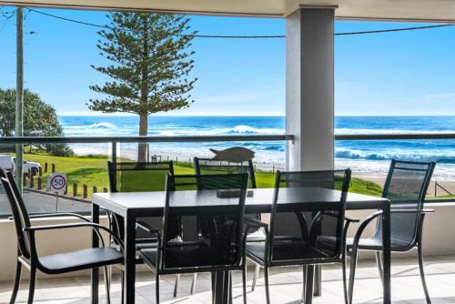 a dining room with a view of the ocean at Sea Breeze - Lennox Head in Lennox Head