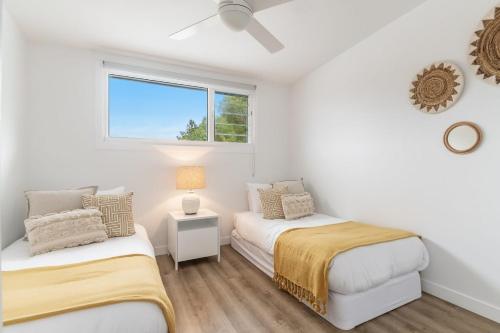 two beds in a white room with a window at Banksia - Lennox Head in Lennox Head