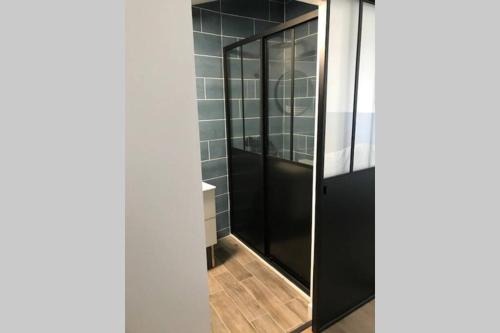 a bathroom with a shower with black glass doors at Bourg superbe appart avec vue magnifique in Bourg-sur-Gironde