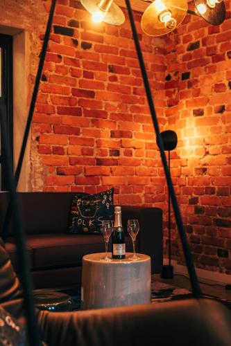 a bottle of wine on a table with two glasses at The Folks Hotel Konepaja in Helsinki